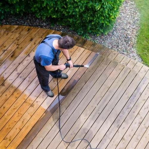 un homme entrain d'entretenir sa terrasse